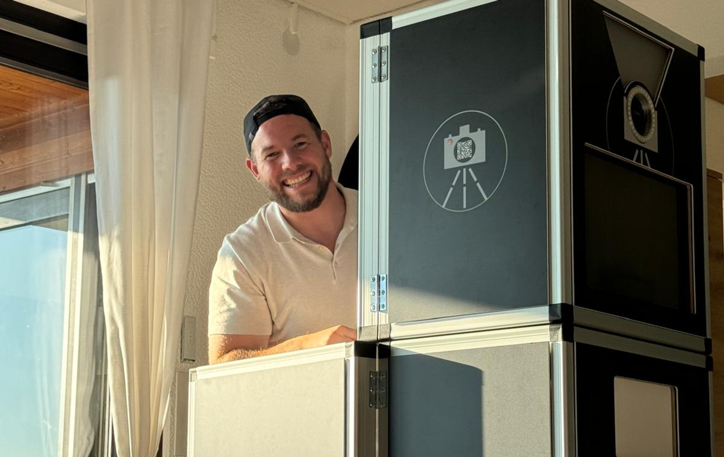 David Sigg lächelnd neben seiner Fotobox